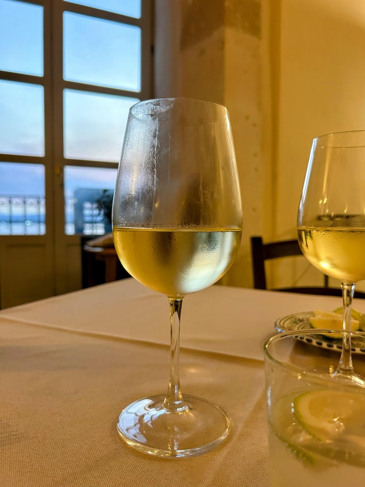 Calici di vino bianco con vista sul mare